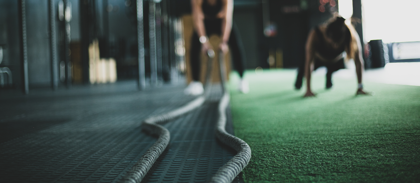 Members training with battle ropes on the IRONHAUS conditioning turf